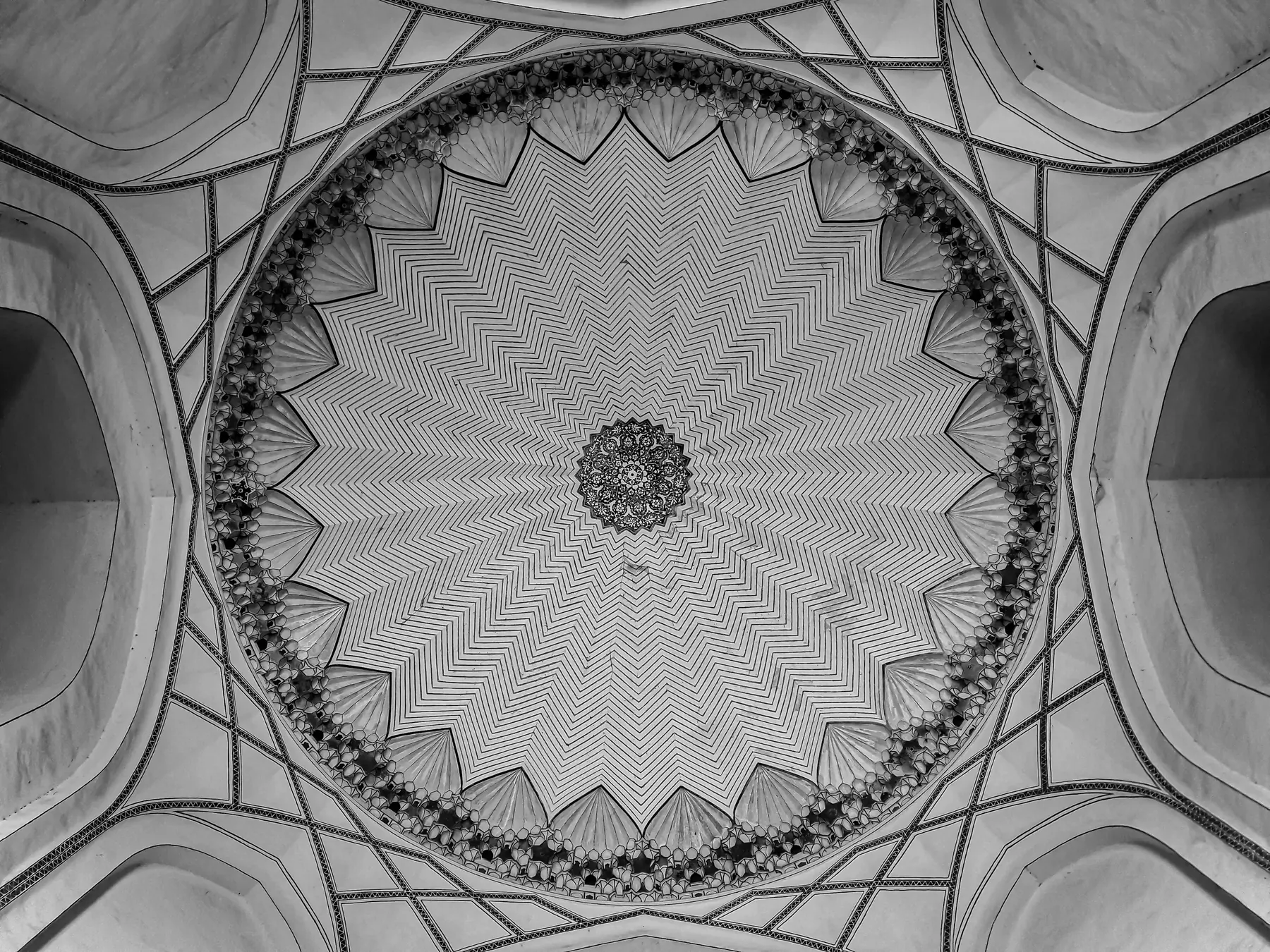 Symmetrical view straight up into a carved dome ceiling